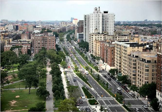 An aerial view of a Bronx, New York boulevard lined with apartment buildings and trees